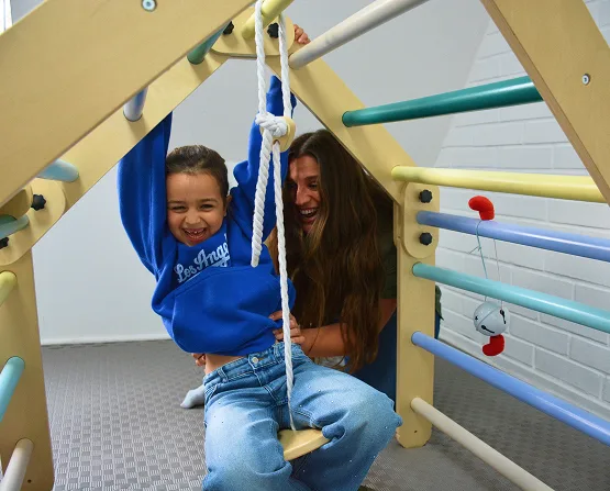 Terapeuta trabajando con una niña sonriente